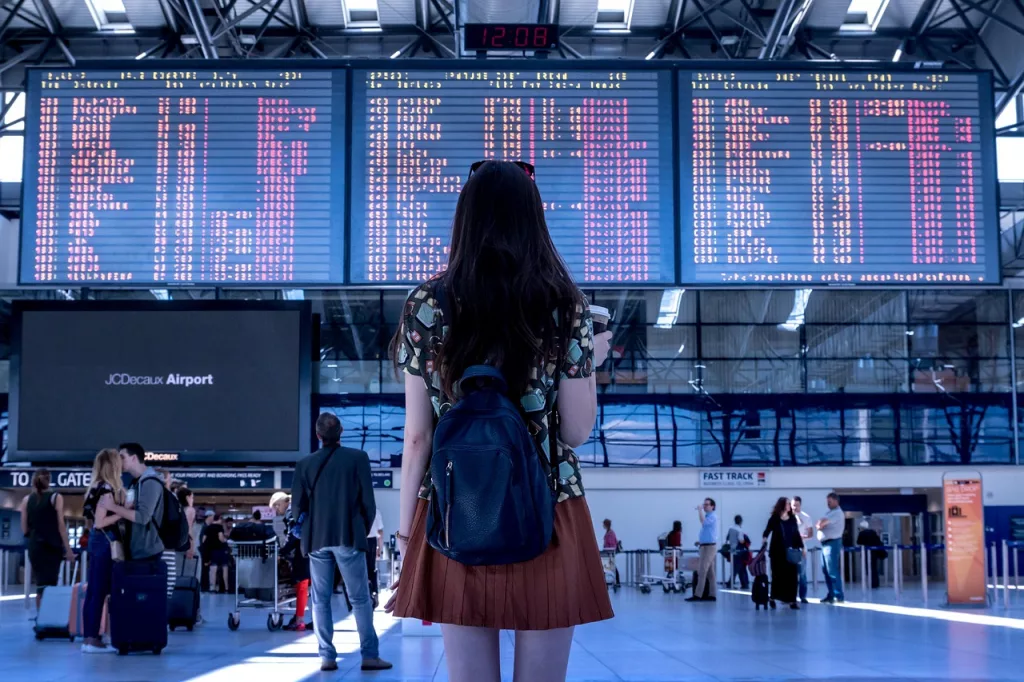 A student checking the departure board before a study abroad flight